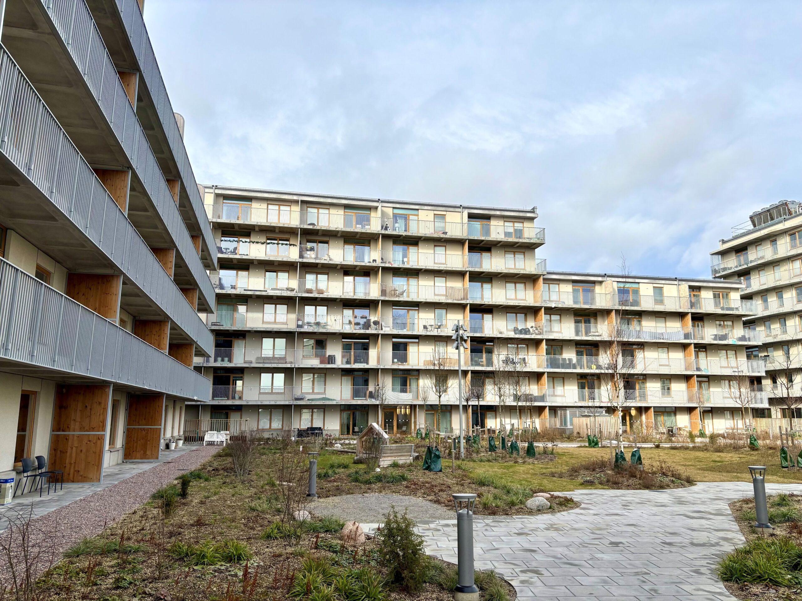 Mehrstöckiges Wohngebäude mit Balkonen und Holz-Elementen in moderner Architektur.