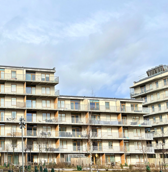 Mehrstöckiges Wohngebäude mit Balkonen und Holz-Elementen in moderner Architektur.