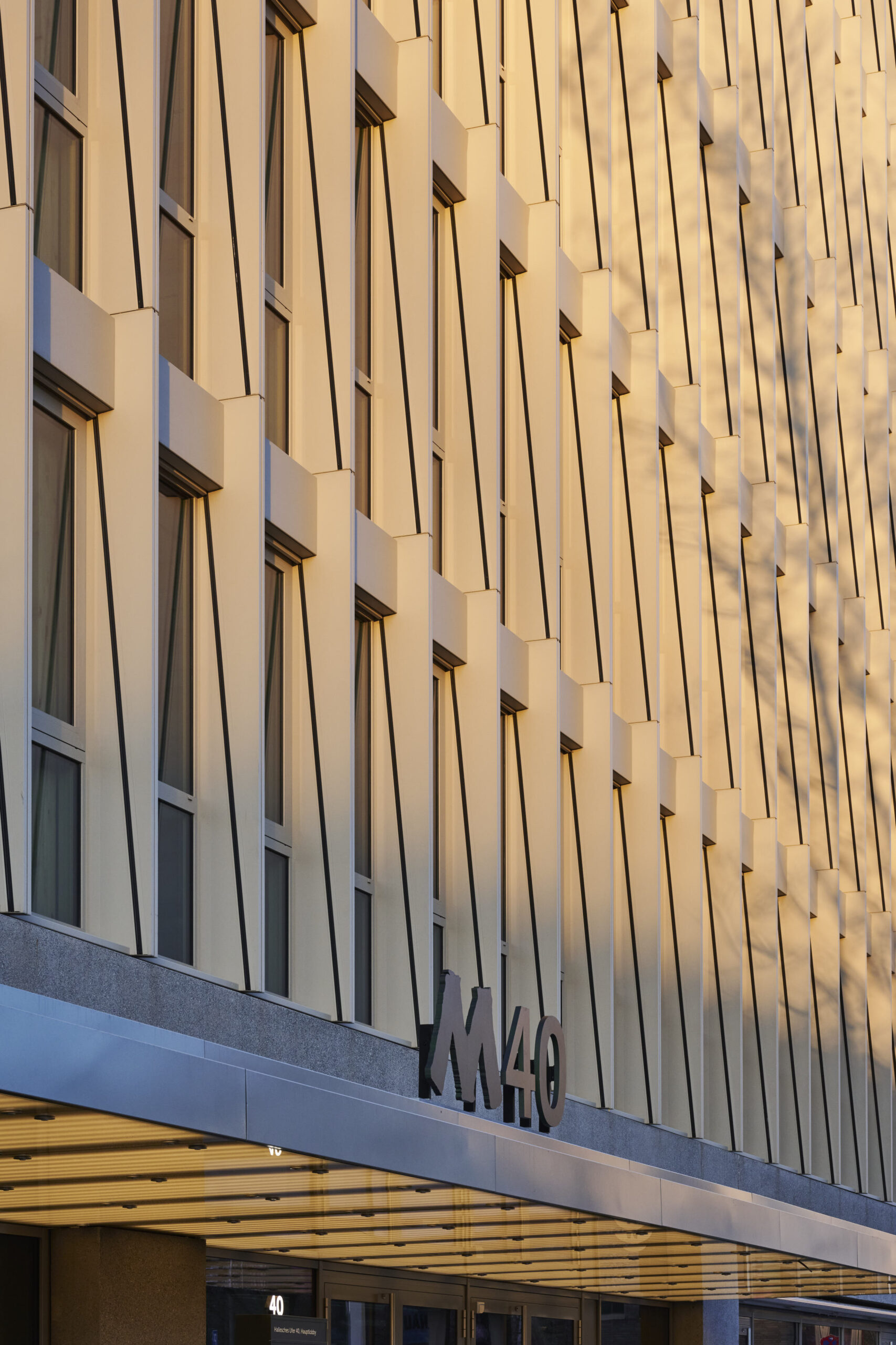 Moderne Bürofassade mit großen Glasfronten und Eingangsbereich mit dem Logo M40.
